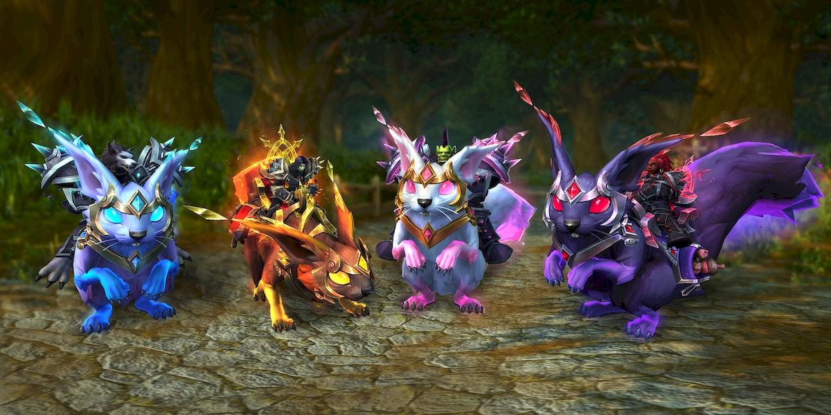 A pic of four Groveglider (flying squirrel) mounts sitting on a forest path. All four have long, elfin ears, glowing eyes, and a soft glow around their bodies. From left to right: Frostfall Groveglider - icy blue & lavender with cyan eyes; Cindertuft Groveglider - brown orange & yellow with yellow eyes; Blossombranch Groveglider - white & pink with pink eyes; Gloombough Groveglider - very dark purple with red eyes.